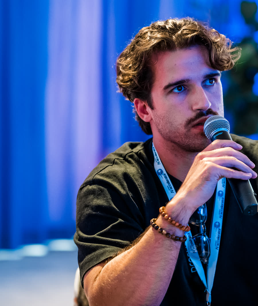 João asking a question into a microphone