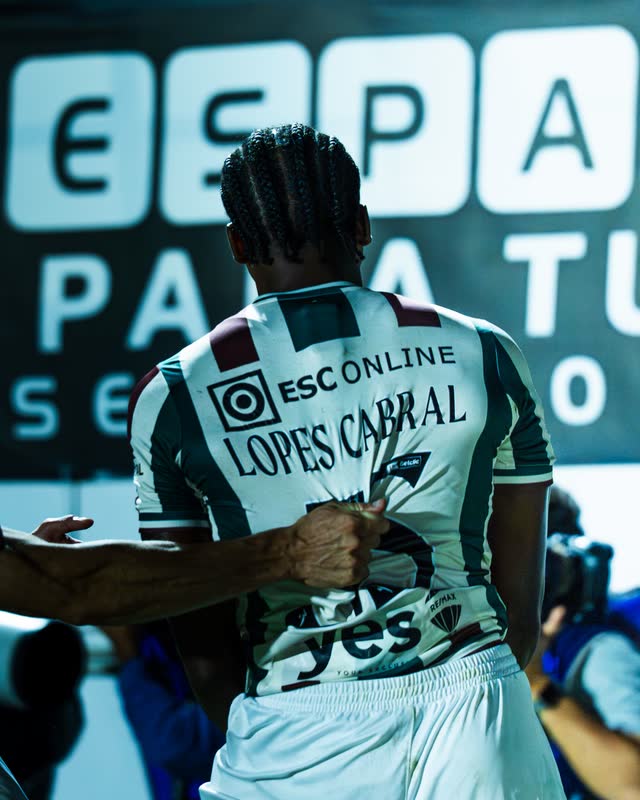 From behind: a player with 'Lopes Cabral' on his shirt, pulled in by a teammate
